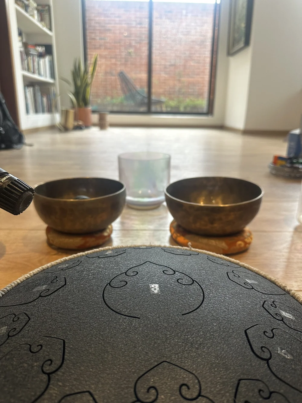 Cuencos tibetanos y tambor de lengüetas sobre el suelo de madera